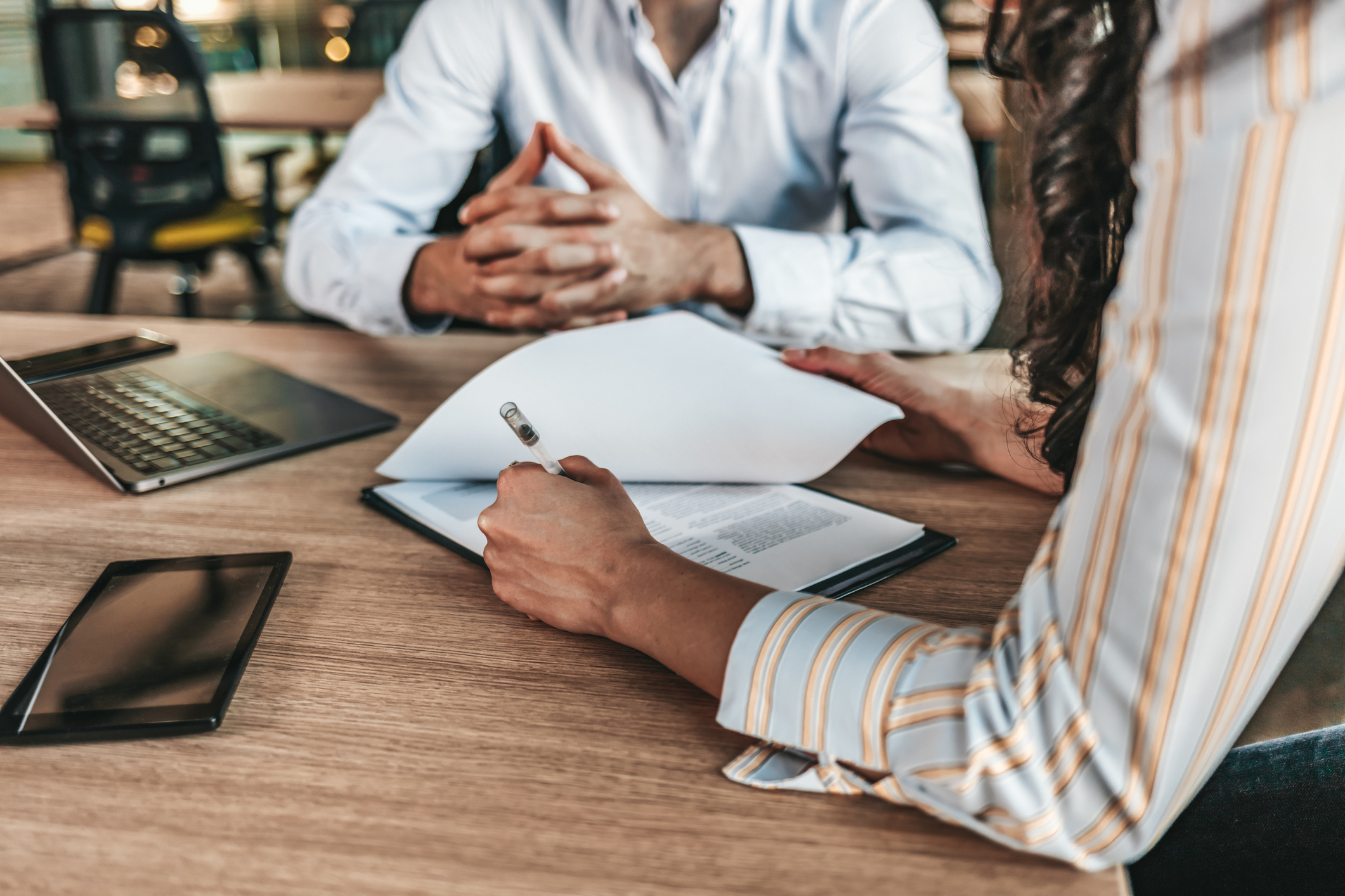Two people go over private mortgage insurance (PMI) paperwork at a desk.