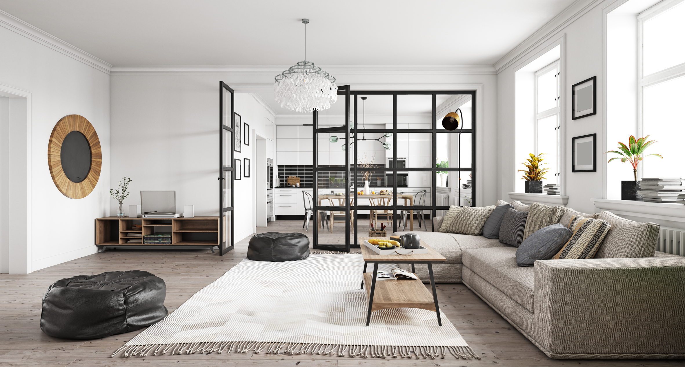An open living room and 厨房 area characterized by a contemporary interior design style. In the forefront of the photo sits a beige couch with grey and brown pillows. The coffee table is wood with black metal legs over a white and beige couch. The living room is separated from the 厨房 in the background by large square framed windows. On the other side you can see white cabinets and a dark grey cement tile back splash and wood table and chairs.